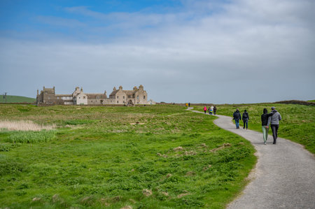 Skaill House at Orkney Island, view from the distance with walking path in front and lots of tourist...