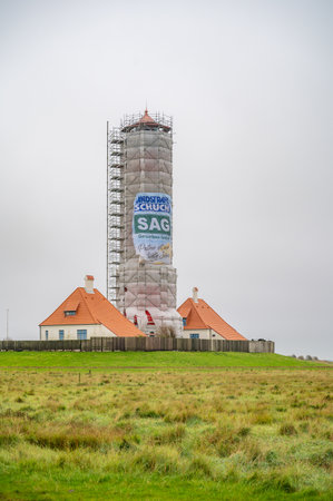 Westerhever Lighthouse construction site during autumn, north sea, germany, vertical shot during cloudy dayのeditorial素材