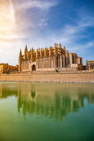 Cathedral of Santa Maria of Palma, La Seu, with lake and reflection in front, sunbeam, vertical shot, Palma de Mallorca, Spainの写真素材