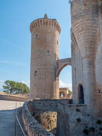 Bellver Castle. Palma de Mallorca, historic stone tower with an arched bridge connects two fortified walls, set against a clear blue sky, Majorcaの写真素材