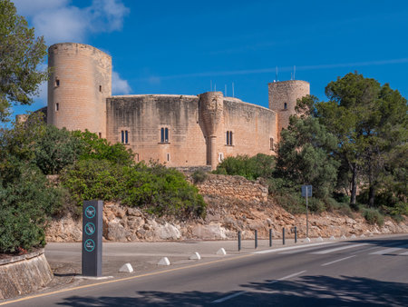 Bellver Castle. Palma de Mallorca, historic castle with round towers sits atop a rocky hill, surrounded by lush greenery, with a clear blue sky overhead, Majorcaの写真素材