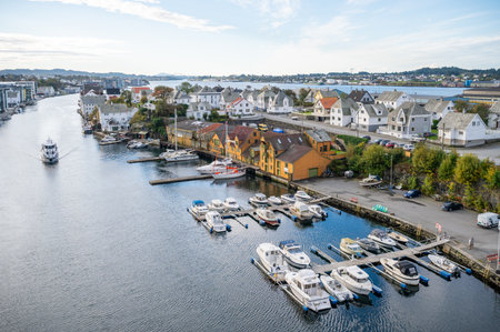 Haugesund harbor with boats docked along the waterfront, surrounded by colorful houses and a serene waterfront, wide angle shot, Norwayの写真素材