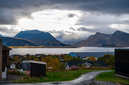 Sortland, Norway, picturesque landscape features a serene fjord with mountains in the background,...