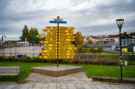 A directional yellow signpost in Narvik, Norway shows various cities and their distances to nearby locations, including Oslo, Berlin, and Parisの写真素材