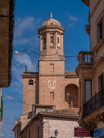 Llucmajor, Mallorca, historic bell tower rises in a sunny European town, with a sign for a repair shop visible below, Majorcaの写真素材