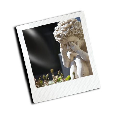 A photography of a sad little angel in a photo frameの写真素材