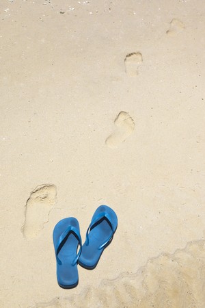 An image of blue thongs at the beachの写真素材