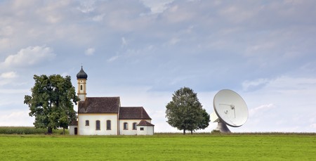 An image of a nice church with satellite dish in bavaria germanyの写真素材