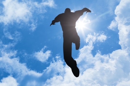 An image of a jumping man in the blue skyの写真素材