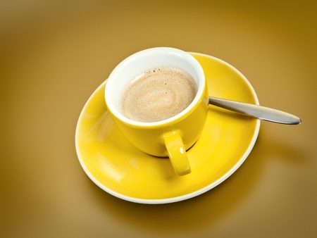 A cup of coffee with on golden backgroundの写真素材