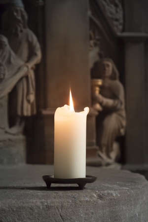 An image of one burning candle in a churchの写真素材