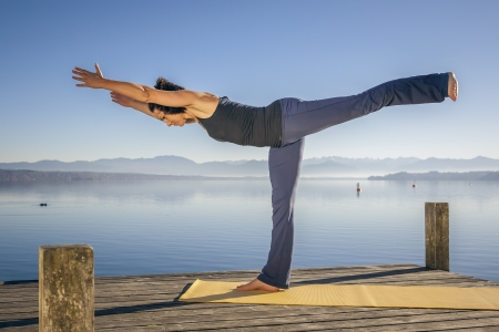 An image of a pretty woman doing yoga at the lakeの写真素材
