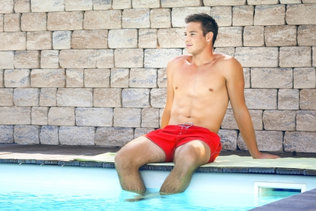 An image of a handsame man relaxing at the poolの写真素材