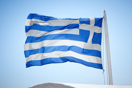 An image of the greek flag under a blue sky
