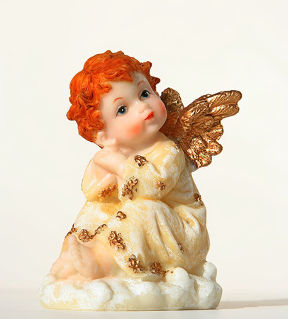 An image of an angel sitting on a white cloud in front of a white backgroundの写真素材
