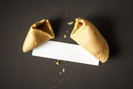 An image of a fortune cookie with a blank paper for your messageの写真素材
