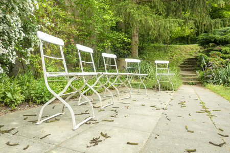 An image of five chairs outside in the green gardenの写真素材