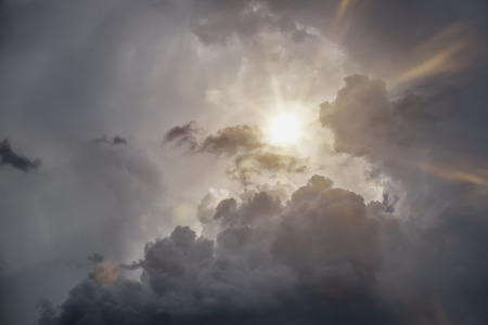An image of a dramatic grey sky with sunの写真素材