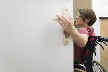An image of a disabled woman at the open door with space for your contentの写真素材