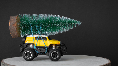 An image of a Christmas tree on a yellow toy carの写真素材