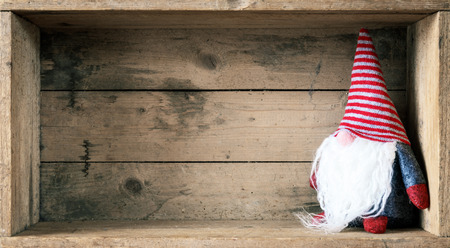 A Christmas decoration with a gnome in a wooden box backgroundの写真素材