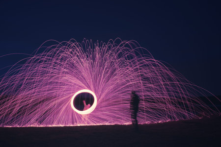 An image of a steel wool firework with shadow of a man