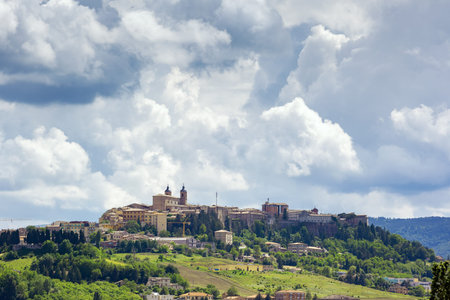 An image of Camerino in Italy Marche over colourful fields
