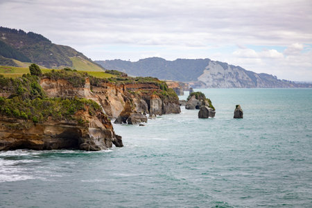 An image of sea shore rocks and mount Taranaki, New Zealand