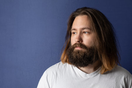 An image of a bearded young man with long hair