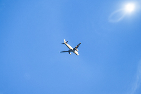 An image of a blue sky with plane and sunの写真素材