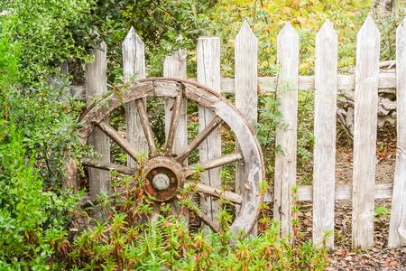 An image of a wooden wheel at a wooden fenceの写真素材