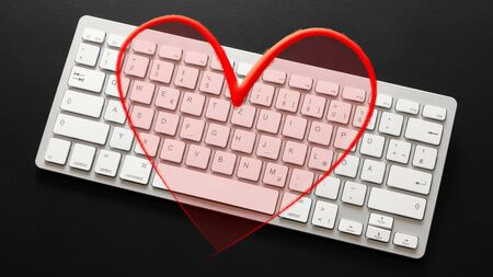 An image of a typical computer keyboard with a red heart overlayの写真素材