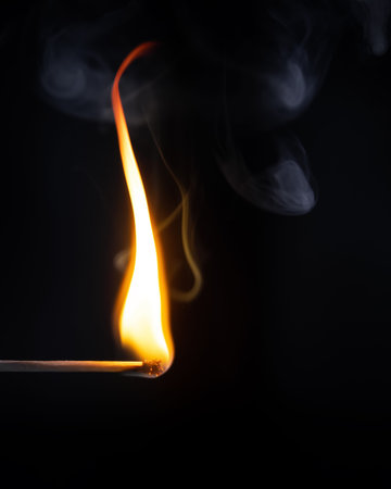 An image of a match flame dark background