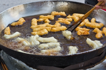 Man cooking deep fried dough stickの写真素材