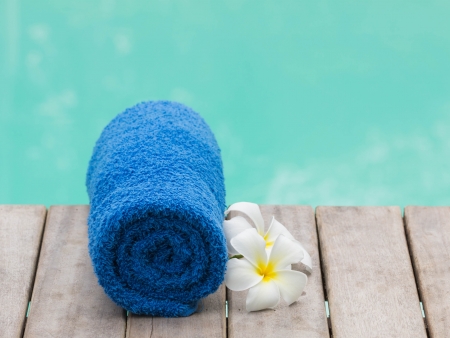 Towel set with flowers beside swimming poolの写真素材