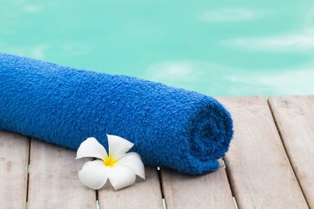 Towel set with flower beside swimming poolの写真素材