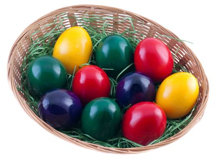 A basket full of colorful easter eggs isolated on white backgroundの写真素材