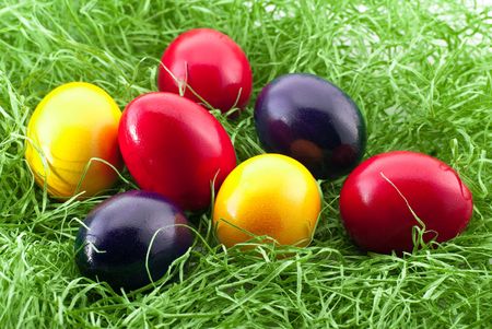 Colorful easter eggs lying on green grassの写真素材