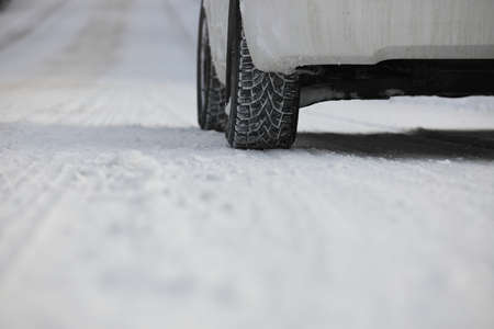 Close up of Winter Tire on Snow and Ice Covered Roadの写真素材