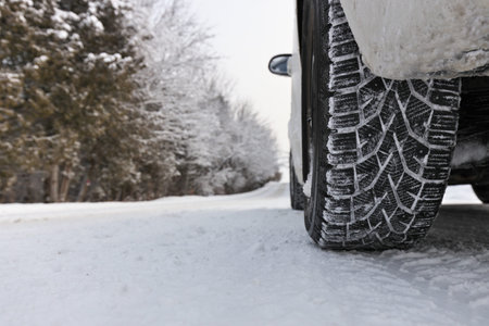 Close up of Winter Tire on Snow and Ice Covered Road