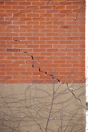 Red Brick Wall and Foundation with Large Crack and crumbling mortarの写真素材