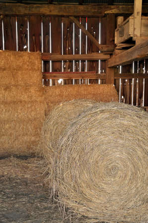 Close up of Round and Square Hay Bales in an old wooden Barnの写真素材