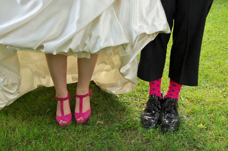 Close up of a Bride and Grooms Funky pink wedding heels and grooms socksの写真素材
