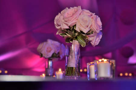 Beautiful wedding bouquet flowers on table at tent reception with pink and purple dramatic lightingの写真素材