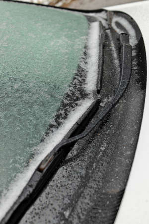 Freezing Rain Creates a Layer of Ice and Coats a Passenger Vehicle. Close up of Windshieldの写真素材