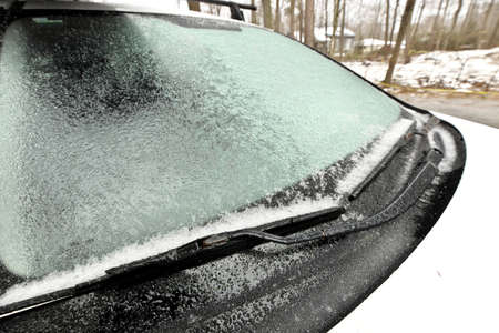 Freezing Rain Creates a Layer of Ice and Coats a Passenger Vehicle. Close up of Windshieldの写真素材