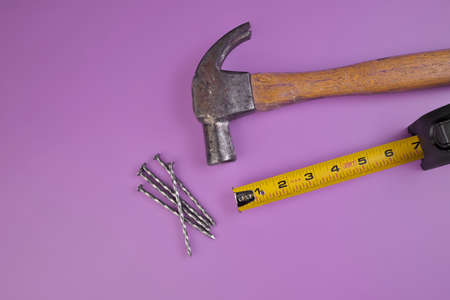 Flatlay of Hammer, Nails, and Tape Measure Isolated on a Lavender Purple Backgroundの写真素材