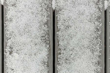 Full Frame Flatlay of A Thin Fresh Layer of Graupel Snow on Gray Deck Boardsの写真素材