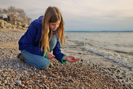 Young Adolescent Girl Collects Beautiful Rocks Pebbles and Shells on the Beach Along Georgian Bay