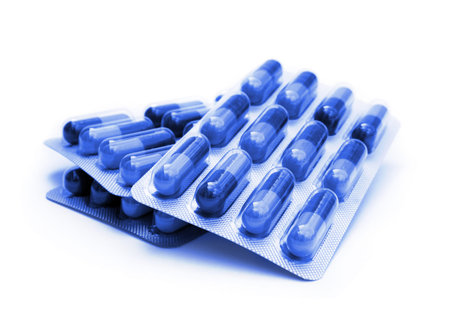 Blister packed capsules on white background (blue toned)
